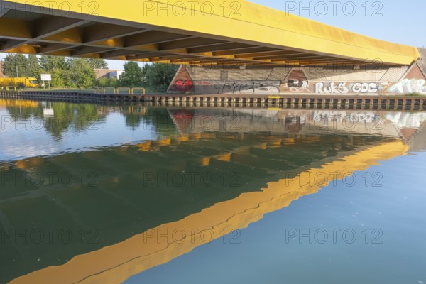 View across the Mittelland Canal to the underside and the graffiti-painted abutment of a bridge on the B6, Hanover, Lower Saxony, Germany