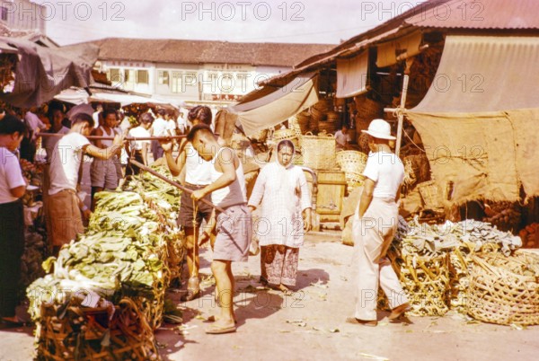 Porters with vegetables people shopping at the old market, Johor Bahru, Johor, Malaya, Malaysia, south east Asia 1963