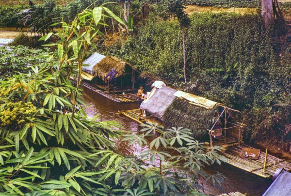 People living in homes on river house rafts, Sungai Perdak, Pahanh, Bentong district, Malaya, Malaysia, south east Asia, 1963 captioned as 'Sungai Peredak'