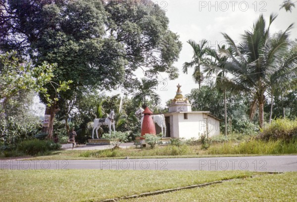 Statues of large white horses stand outside Kutherai kovil unregistered Hindu temple shrine, Woodlands Road, Singapore, south east Asia 1963 removed c 1993