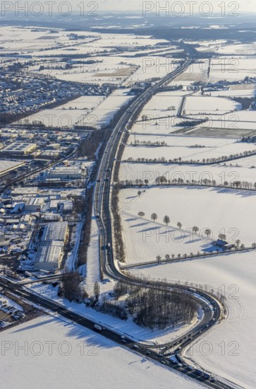 Aerial view, motorway access to the A445 motorway on the B63 Hammer Landstraße federal road, industrial area, commercial area, snow, winter, Budberg, Werl, Soester Börde, North Rhine-Westphalia, Germany, Soester, Börde, DE, Europe, birds-eyes, view, aerial photograph, aerial photography, aerial photography, overview, overview, bird's eye view, A445, B63, industry, commerce, economy, commercial enterprise, production, trade, manufacturing, transport, traffic, infrastructure, logistics, road traffic