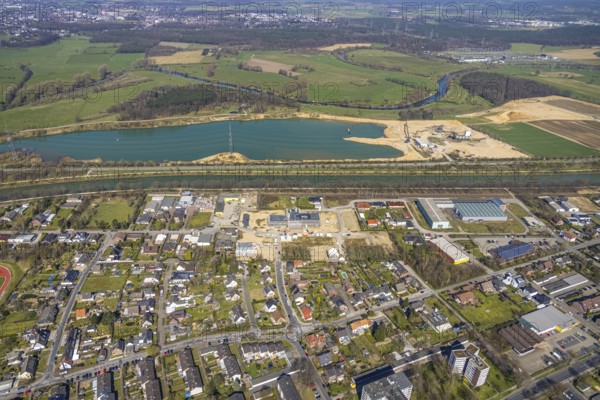 Aerial view, construction site and new building in the industrial estate Friedrichsfeld, Poststraße, Wesel-Datteln-Kanal, RMKS RHEIN MAIN KIES UND SPLITT with lake, river Lippe with Lippe floodplain, Friedrichsfeld, Voerde, Ruhr area, Lower Rhine, North Rhine-Westphalia, Germany, construction work, construction area, construction site, building plots, construction, construction project, construction site, DE, Europe, commercial enterprises, commercial area, commercial area, commercial site, commercial use, industrial area, industrial site, aerial view, aerial photography, aerial photography, new construction, overview, bird's-eye view, overview