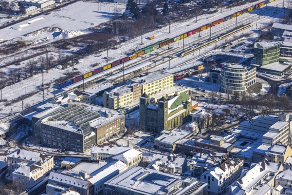 Aerial view, Unna railway station, catholic church St. Katharina, Unna, Ruhr area, North Rhine-Westphalia, Germany, place of worship, railway tracks, railway station, Bahnhofstraße, station forecourt, bus station, DE, Deutsche Bahn AG, Europe, gastronomy, religious community, railway tracks, place of worship, goods train, main station, main station, holy place, hotel, hotel facilities, hotel industry, Kantstraße, Katharinen Hof, church, parish, denomination, aerial view, aerial photography, aerial photography, religion, religious site, snow, overview, bird's-eye view, winter, onset of winter, winter landscape, ZOB, trains, birds-eyes view, overview