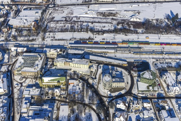 Aerial view, Unna railway station, Viktoriastrasse development area for office building, St. Katharina Catholic Church, Hotel Katharinen Hof, Unna, Ruhr area, North Rhine-Westphalia, Germany. Katharina, Hotel Katharinen Hof, Unna, Ruhr area, North Rhine-Westphalia, Germany, place of worship, railway tracks, railway station, Bahnhofstraße, station forecourt, bus station, DE, Deutsche Bahn AG, Europe, gastronomy, religious community, railway tracks, place of worship, main railway station, main station, holy site, hotel, hotel facilities, hotel industry, Kantstraße, Katharinen Hof, church, church community, denomination, aerial view, aerial photography, aerial photography, religion, religious site, snow, overview, bird's-eye view, winter, onset of winter, winter landscape, ZOB, trains, birds-eyes view, overview