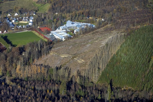 Aerial view, forest area with forest damage and sports and conference centre Hachen in the district Hachen in Sundern, Sauerland, North Rhine-Westphalia, Germany, tree dieback, bark beetle damage, bark beetle plague, DE, Europe, spruce dieback, clear-cutting, aerial view, aerial photography, aerial photography, sports field, sports centre, Sundern, overview, bird's eye view, forest, forest damage, forest dieback, birds-eyes view, overview