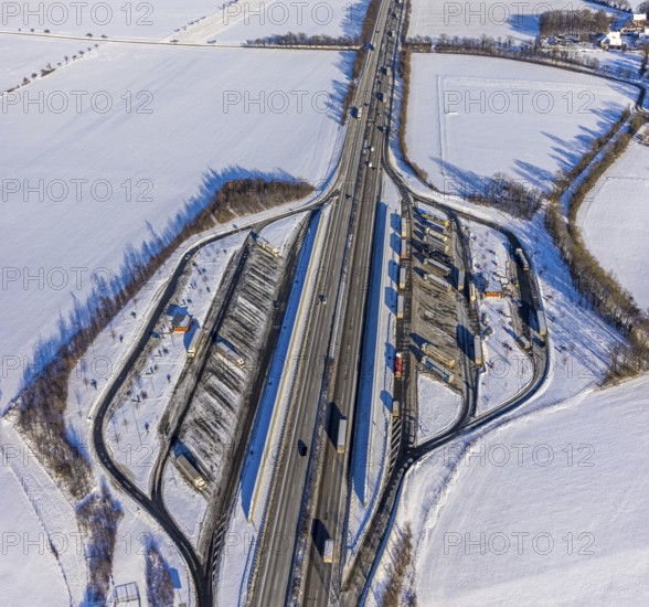 Aerial photo, Ostönner Grund rest area on the A44 motorway, snow, winter, rest areas, trucks, Röllingsen, Soest, Soester Börde, North Rhine-Westphalia, Germany, Soester, Börde, DE, Europe, birds-eyes, view, aerial photography, aerial photography, overview, overview, bird's eye view, winter weather, onset of winter, cold, rest area, Ostönner, Grund, transport, traffic, infrastructure, logistics, road traffic, parking, cars, parking area
