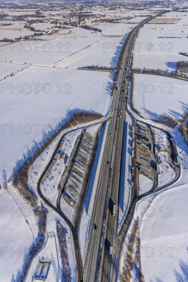 Aerial photo, Ostönner Grund rest area on the A44 motorway, snow, winter, rest areas, trucks, Röllingsen, Soest, Soester Börde, North Rhine-Westphalia, Germany, Soester, Börde, DE, Europe, birds-eyes, view, aerial photography, aerial photography, overview, overview, bird's eye view, winter weather, onset of winter, cold, rest area, Ostönner, Grund, transport, traffic, infrastructure, logistics, road traffic, parking, cars, parking area