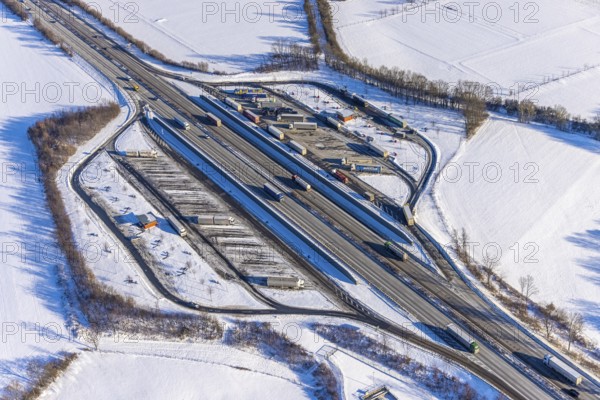 Aerial photo, Ostönner Grund rest area on the A44 motorway, snow, winter, rest areas, trucks, Röllingsen, Soest, Soester Börde, North Rhine-Westphalia, Germany, Soester, Börde, DE, Europe, birds-eyes, view, aerial photography, aerial photography, overview, overview, bird's eye view, winter weather, onset of winter, cold, rest area, Ostönner, Grund, transport, traffic, infrastructure, logistics, road traffic, parking, cars, parking area