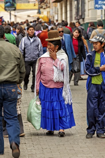 Woman in traditional dress with bag walking through a busy street, Traditionally dressed woman in the streets of La Paz Bolivia