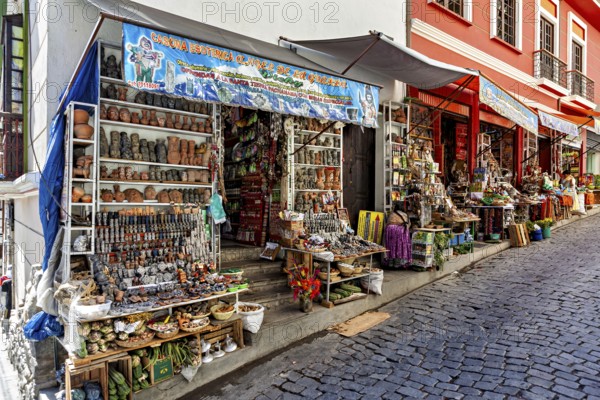 Steep street with shops selling pottery and souvenirs. Colourful facades create a nostalgic market atmosphere, The witches' market of La Paz in Bolivia