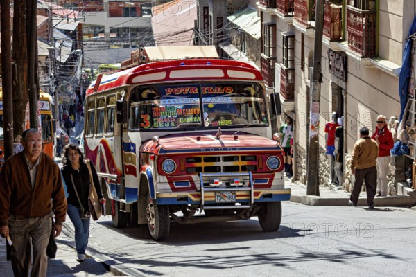 A colourful bus drives through a sunny, busy street in a South American city, A colourful bus in the streets of La Paz Bolivia