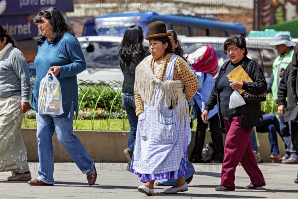 Woman in traditional dress with hat walking on a busy street, Traditionally dressed woman in the streets of La Paz Bolivia