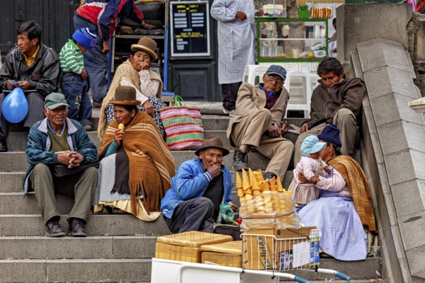 People in traditional dress sit on a staircase and talk near a market stall with ice cream, Traditionally dressed people sit on a staircase in La Paz Bolivia