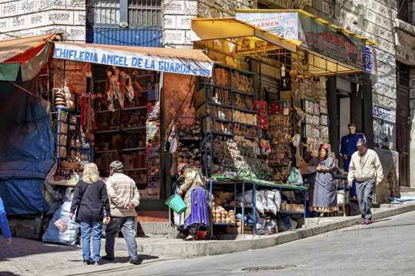 A busy market stall with souvenirs on a street corner surrounded by people, The witches' market of La Paz in Bolivia