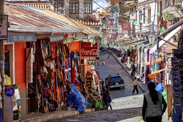 A lively street with colourful shops and people in a mountainous setting, the witches' market in La Paz, Bolivia