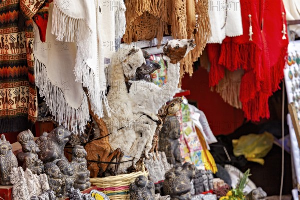 A market stall with a llama figure and colourful textiles represents Andean culture, The witches' market in La Paz, Bolivia