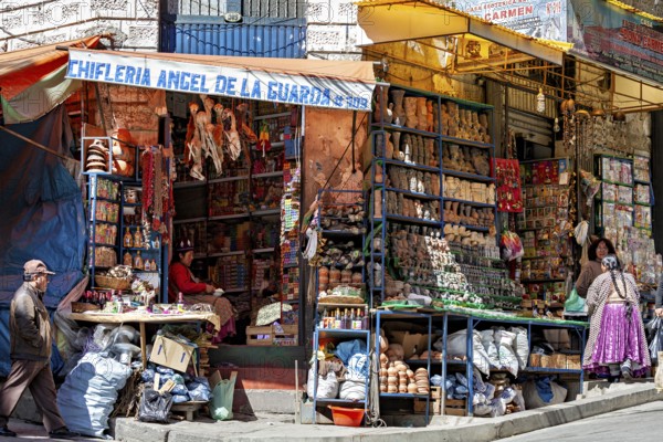 A street scene with a stall full of colourful goods and people in traditional dress, the witches' market in La Paz, Bolivia