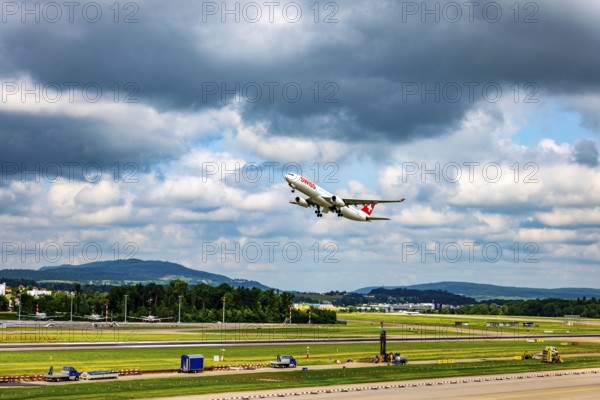 Swiss Airlines Passenger Airplane Take Off From the Runway and Flying Against Blue Sky and Clouds in a Sunny Summer Day From the Airport in Kloten, Zurich, Zurich Canton, Switzerland