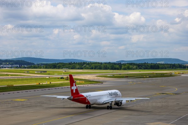 Helvetic Airways Passenger Airplane Taxiing on Runway in a Sunny Summer Day From the Airport in Kloten, Zurich, Zurich Canton, Switzerland