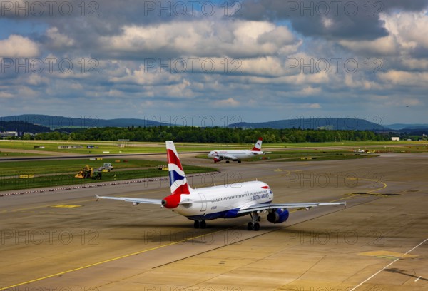 British Airways and Austrian Airlines Passenger Airplane Taxiing on Runway in a Sunny Summer Day From the Airport in Kloten, Zurich, Zurich Canton, Switzerland