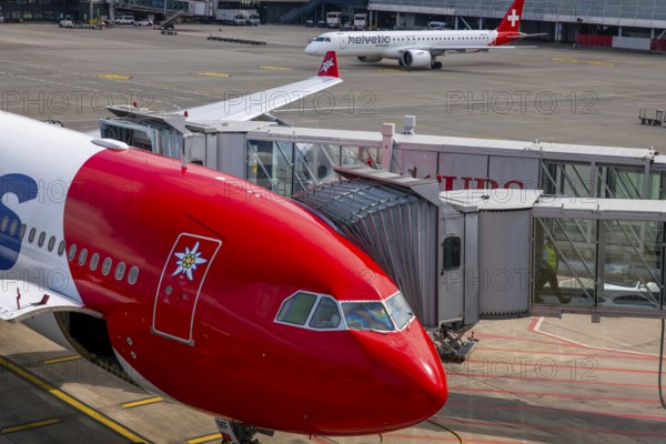 Zurich Airport and Passenger Airplane and Boarding Bridge Gate on Airfield in a Sunny Summer Day From the Airport in Kloten, Zurich, Zurich Canton, Switzerland