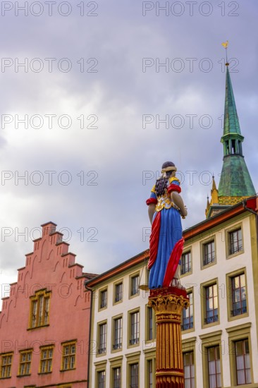 Old Town with House and Water Fountain with Statue and Tower with Sky and Clouds in a Sunny Autumn Day in City of Biel, Bienne, Bern Canton, Switzerland