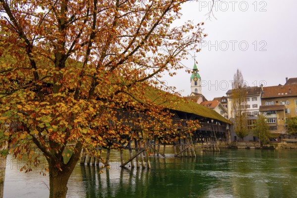 Old Town and the Historical Covered Wood Bridge Holzbrücke over River Aare in an Autumn Day in Olten, Solothurn Canton, Switzerland