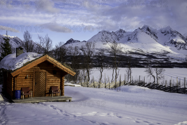 Wooden hut, snow mountains norway tromsö lake frozen over