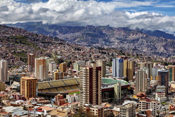 Urban landscape of La Paz with skyscrapers, a stadium and mountains in the background, The houses and skyscrapers of the city centre of La Paz in Bolivia