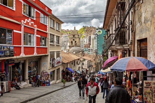 Busy street with colourful buildings and umbrellas in an urban environment, people in the streets of La Paz in Bolivia