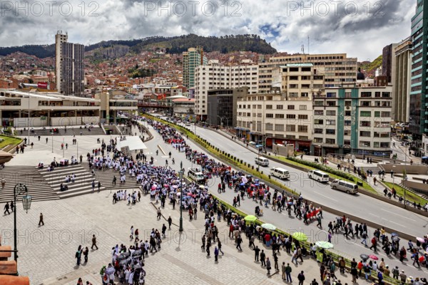 City view with crowd on square and street, surrounded by high buildings and mountains in the background, A demonstration in the streets of La Paz in Bolivia