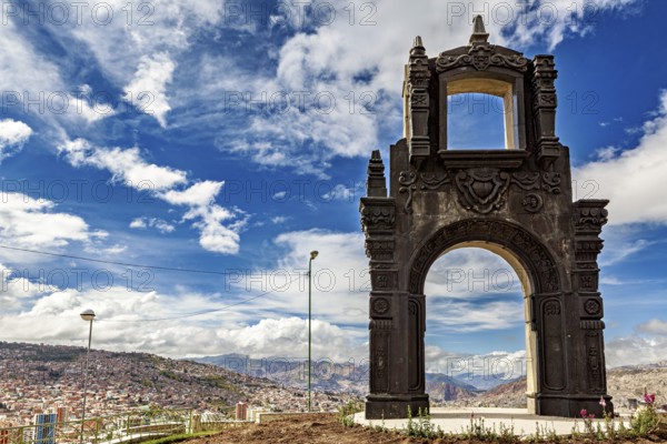 An artistically designed stone gate with a view of a city and clouds in the sky, The gate at the Killi Killi viewpoint in La Paz, Bolivia
