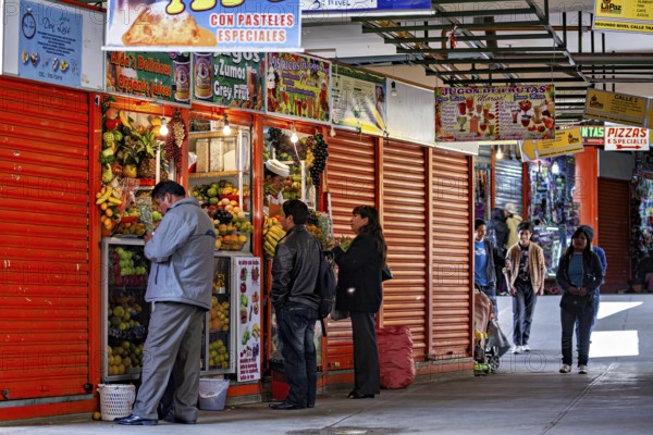 Busy market with people buying fresh vegetables and other food, small shops and restaurants in the market halls of La Paz in Bolivia