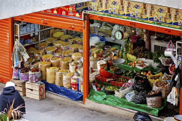 Lush market stall with different types of grain and traditional foods, small shops and restaurants in the market halls of La Paz in Bolivia
