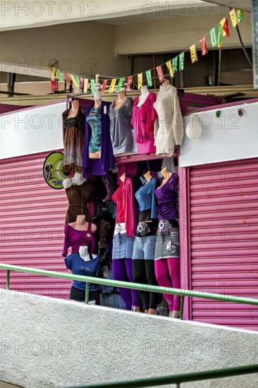 Shop window with colourful, modern clothing in a feminine shop, Small shops and restaurants in the market halls of La Paz in Bolivia