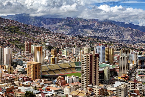 City panorama of La Paz with tall buildings and mountains behind under a cloudy sky, The houses and skyscrapers of the city centre of La Paz in Bolivia