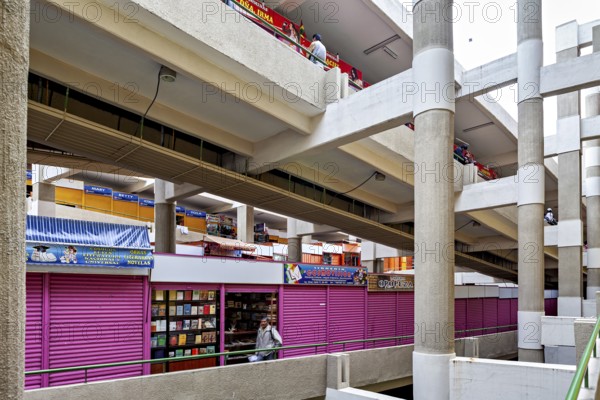 Interior view of a multi-storey market with colourful facades and various stalls, small shops and restaurants in the market halls of La Paz in Bolivia