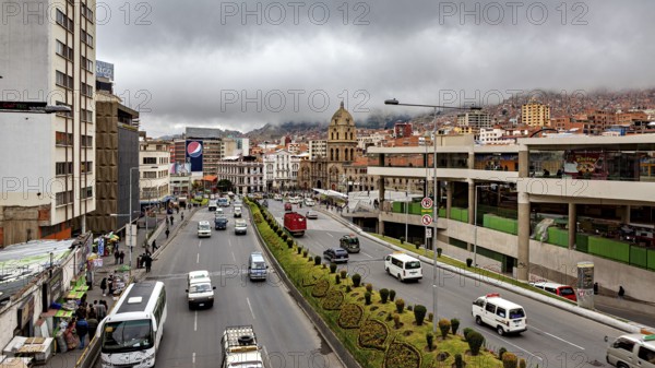 Urban scene with a wide street, traffic, a church and clouds over the mountains, The main streets in the city centre of La Paz in Bolivia