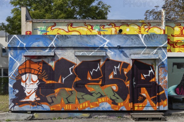 Colourful graffiti wall with lively figures and letters in an urban environment, at the port of Linz Upper Austria Austria