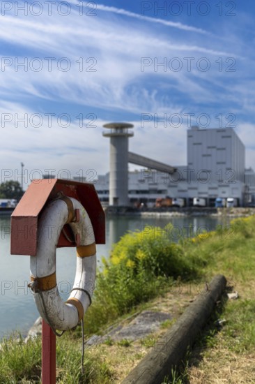 Lifebuoy in front of an industrial area in a partly cloudy sky, at the harbour of Linz Upper Austria Austria