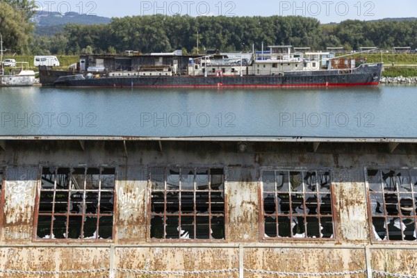 Industrial landscape with abandoned plant and ships in the background, at the harbour of Linz Upper Austria Austria