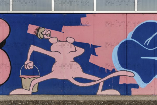 Lively cartoon mural with figure and bucket in pink tones, at Linz harbour Upper Austria Austria