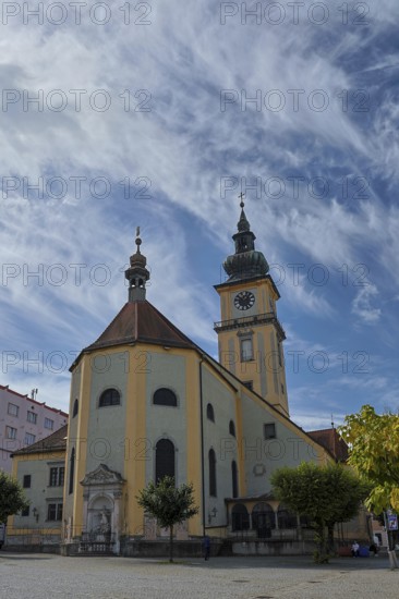 Baroque church with clock tower on a square under a partly cloudy sky, Stadtpfarrkirche Maria Himmelfahrt Linz Austria