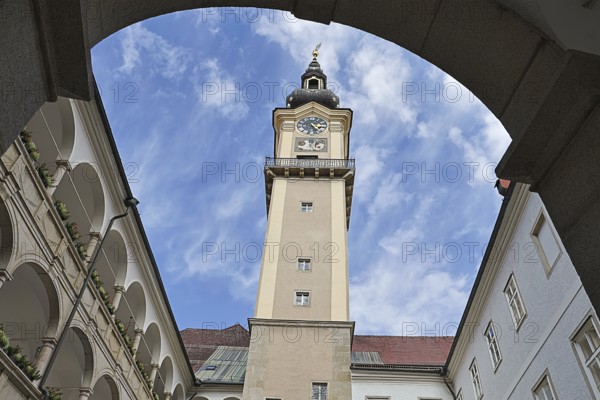 Historic clock tower above an inner courtyard with sky and surrounding arcades, Arkardenhof Landhaus Linz Upper Austria Austria