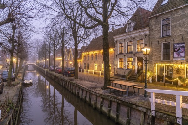Typical canal in the foggy evening twilight, Harlingen, Friesland, Netherlands