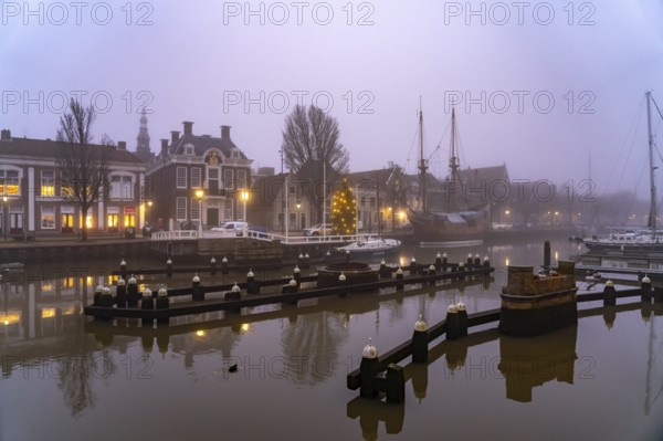 Typical canal in the foggy evening twilight, Harlingen, Friesland, Netherlands