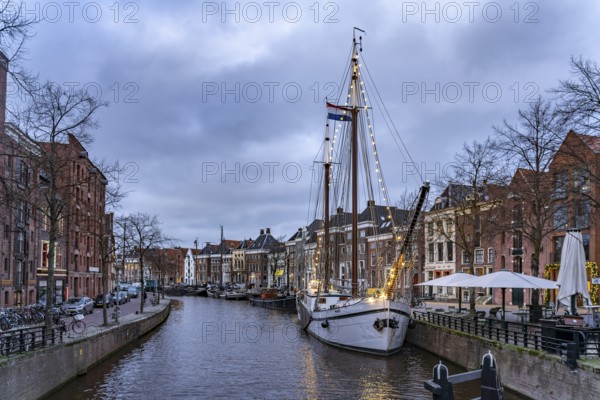 Typical canal with sailing boats in Groningen at dusk, Netherlands
