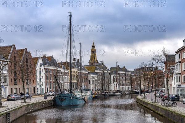 Typical canal with sailing boats and the tower of the Aa church in Groningen, Netherlands