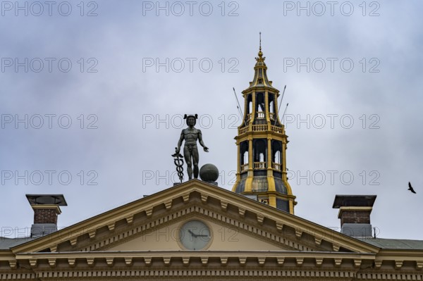 Statue of the god Mercury on the roof of the Korenbeurs former grain exchange and the steeple of the Aa church in Groningen, Netherlands