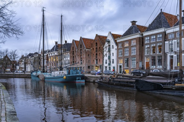 Typical canal with sailing boats in Groningen at dusk, Netherlands